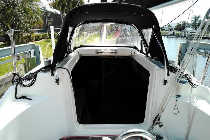 Slide: The Image of 2011 MacGregor 26M sailboat cockpit with canopy, docked by a canal. - 15