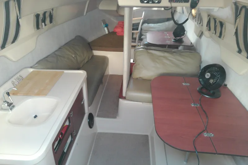 Slide: The Image of Interior of a 2011 MacGregor 26M sailboat with kitchenette and seating area. - 16