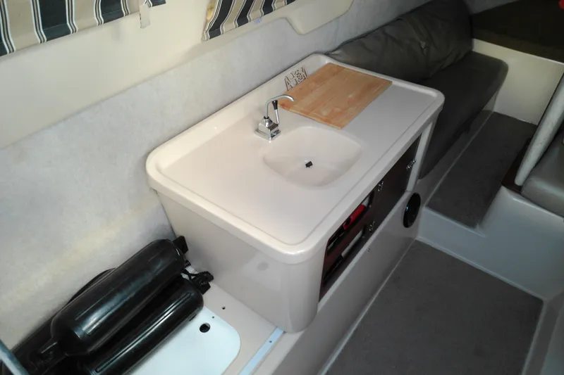 Slide: The Image of Interior of 2011 MacGregor 26M sailboat with compact sink and seating area. - 17