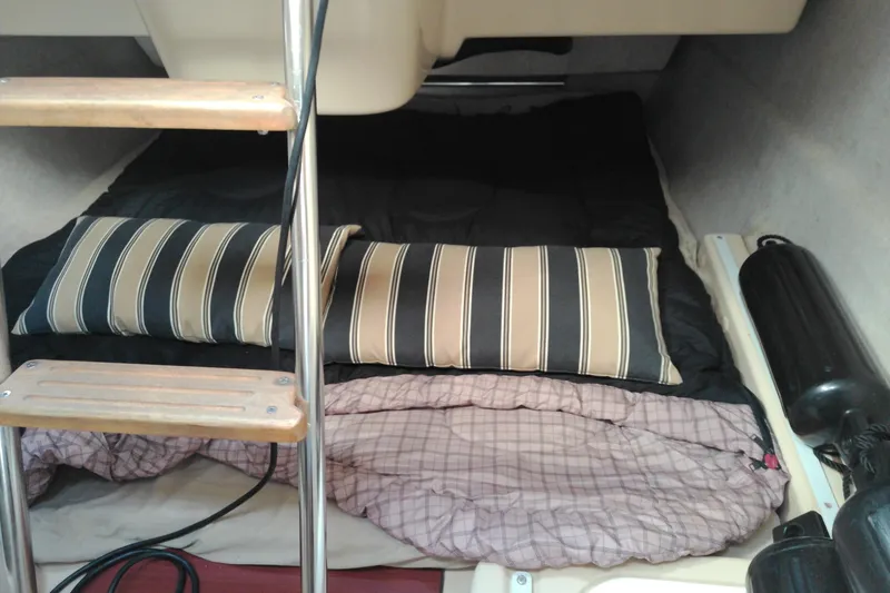 Slide: The Image of Interior cabin of 2011 MacGregor 26M sailboat with striped pillows and sleeping area. - 19