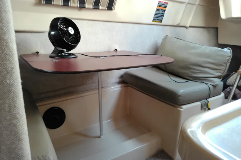 Slide: The Image of Cozy interior of 2011 MacGregor 26M sailboat with table and fan. - 23