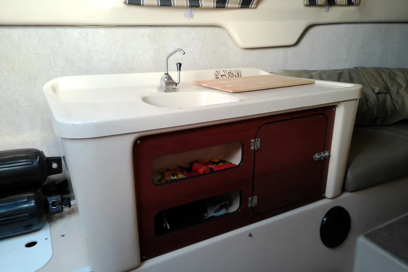 Slide: The Image of Interior of 2011 MacGregor 26M sailboat with compact kitchenette and storage. - 29