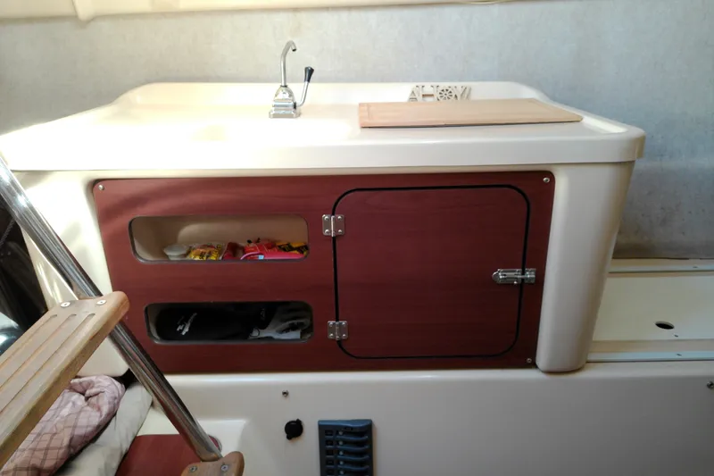 Slide: The Image of Interior of 2011 MacGregor 26M sailboat with sink and storage compartments. - 31