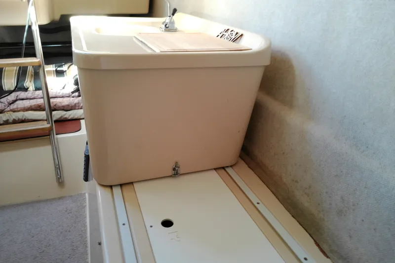 Slide: The Image of Interior of 2011 MacGregor 26M sailboat with compact sink and ladder. - 33
