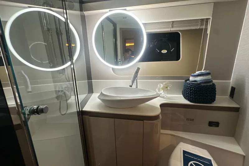 Slide: The Image of Luxurious bathroom in 2026 Cruisers Yachts 50 Fly with modern fixtures and illuminated mirror. - 21