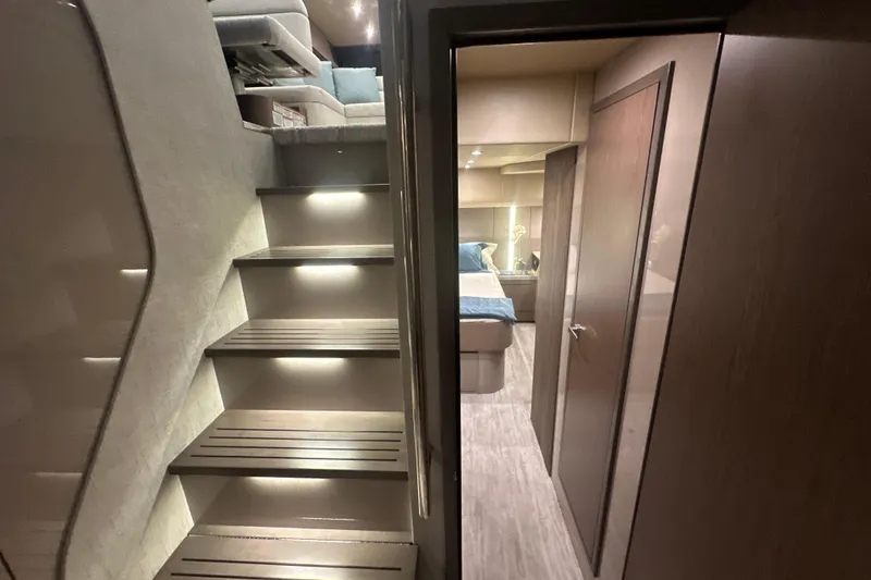 Slide: The Image of Interior of 2026 Cruisers Yachts 50 Fly, featuring modern stairs and cozy bedroom. - 22