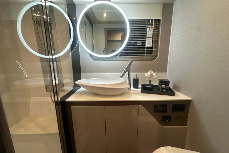 Slide: The Image of Luxurious bathroom in 2026 Cruisers Yachts 50 Fly, featuring modern sink and illuminated mirrors. - 33