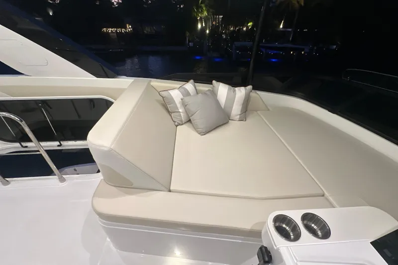 Slide: The Image of Luxurious seating area on 2026 Cruisers Yachts 50 Fly, featuring elegant cushions and cup holders. - 49