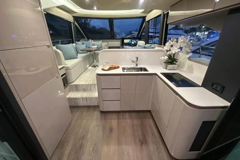 Slide: The Image of Luxurious interior of 2026 Cruisers Yachts 50 Fly, featuring modern kitchen and seating area. - 5