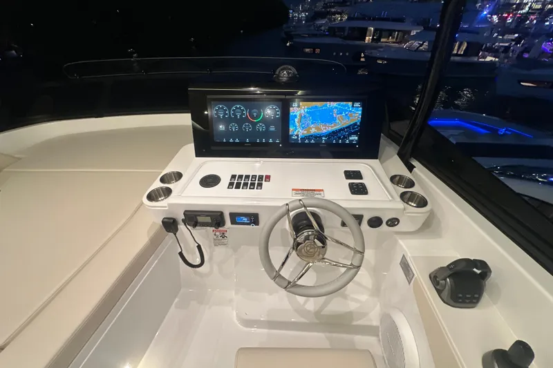 Slide: The Image of Helm of 2026 Cruisers Yachts 50 Fly with advanced navigation displays at night. - 51