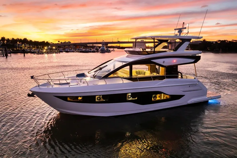 Slide: The Image of 2026 Cruisers Yachts 50 Fly at sunset, docked in a serene marina. - 53