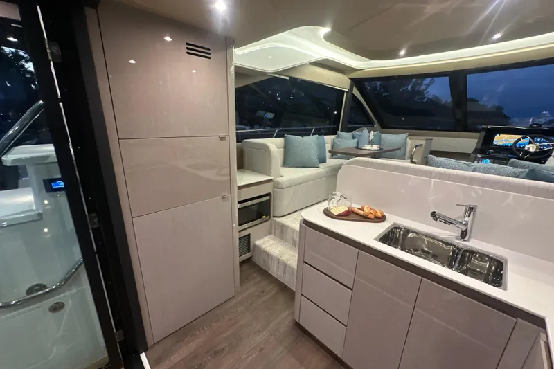 Slide: The Image of Luxurious interior of 2026 Cruisers Yachts 50 Fly with modern kitchen and seating area. - 7