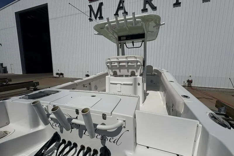 Slide: The Image of 2021 Sea Hunt boat with fishing rod holders, docked near a marina building. - 4