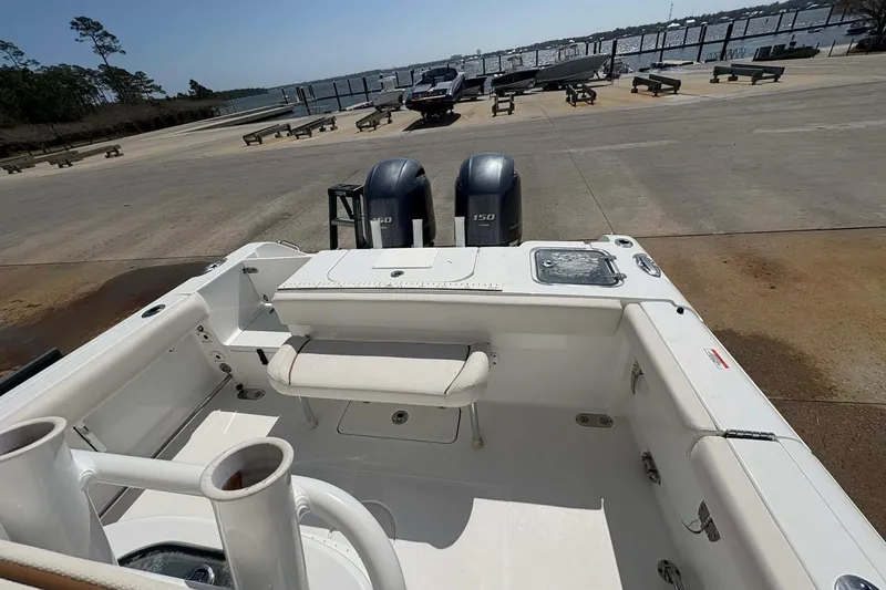 Slide: The Image of 2021 Sea Hunt boat with dual 150 horsepower engines at a dockside location. - 6