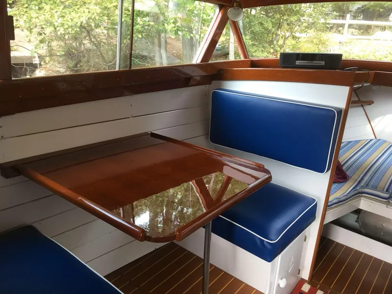 Slide: The Image of 1956 Chris-Craft Captain boat interior with blue seating and wooden table. - 6