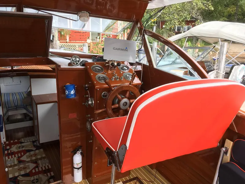 Slide: The Image of 1956 Chris-Craft Captain boat interior with red seating and vintage wooden dashboard. - 9