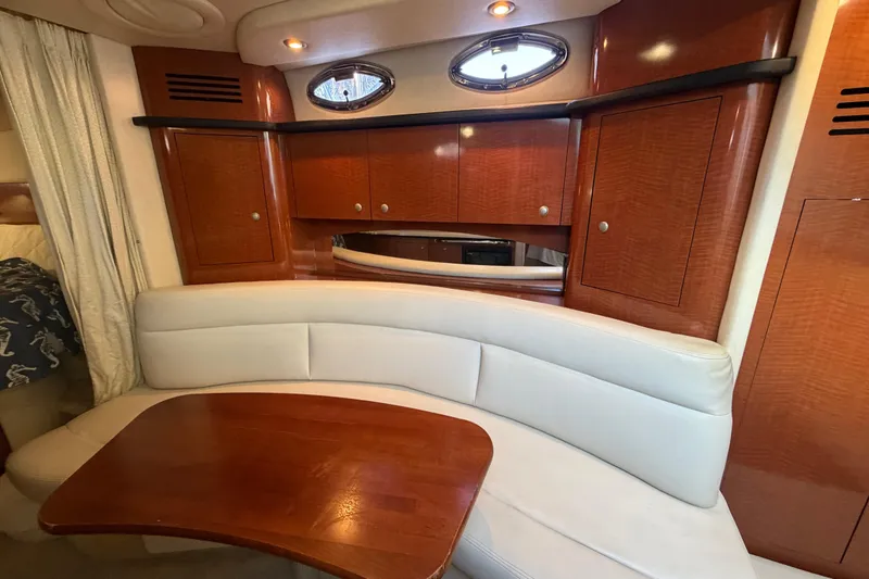 Slide: The Image of 2005 Sea Ray Sundancer 320 interior with curved seating and wooden cabinetry. - 16