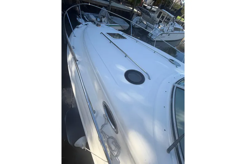 Slide: The Image of 2005 Sea Ray Sundancer 320 boat docked, showcasing sleek white deck design. - 9