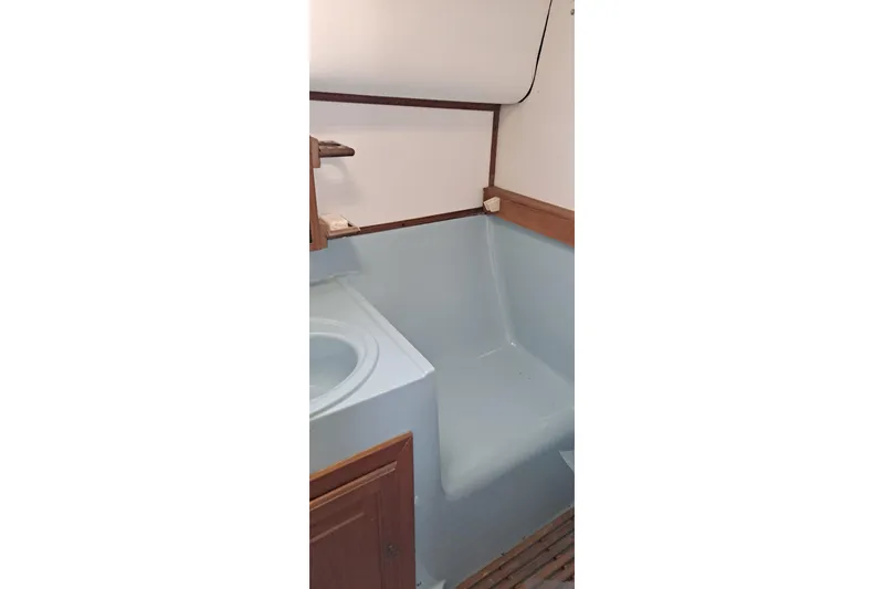 Slide: The Image of 1979 Mainship 34 Sedan bathroom interior with sink and seating area. - 11