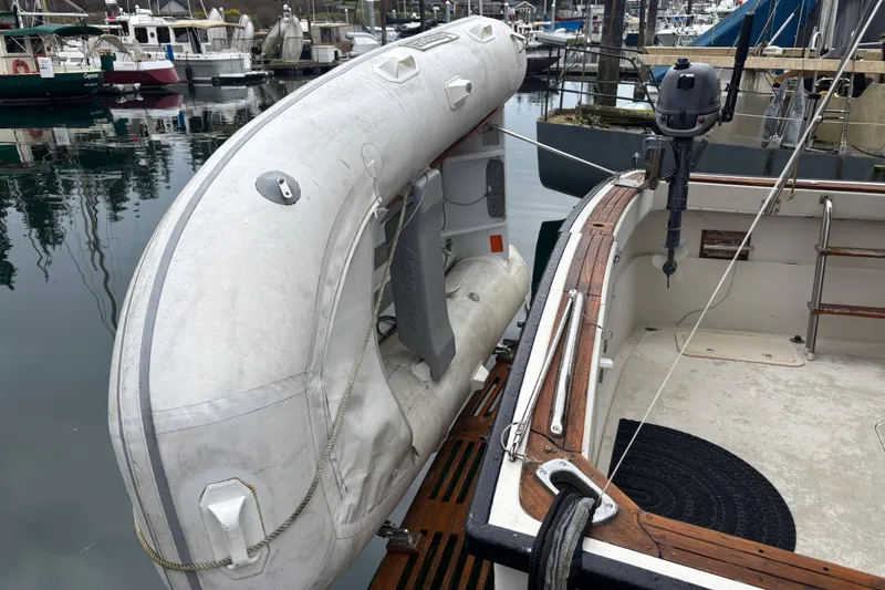 Slide: The Image of 1979 Mainship 34 Sedan with inflatable dinghy and outboard motor at marina. - 15