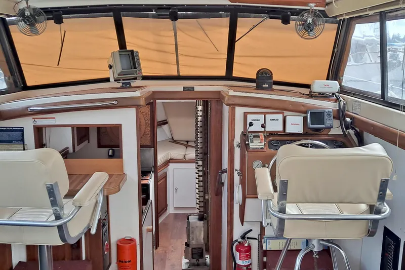 Slide: The Image of 1979 Mainship 34 Sedan interior with helm, seating, and navigation equipment. - 2