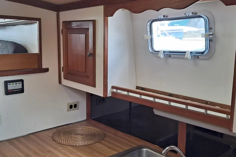 Slide: The Image of 1979 Mainship 34 Sedan interior with wooden cabinetry and window. - 5
