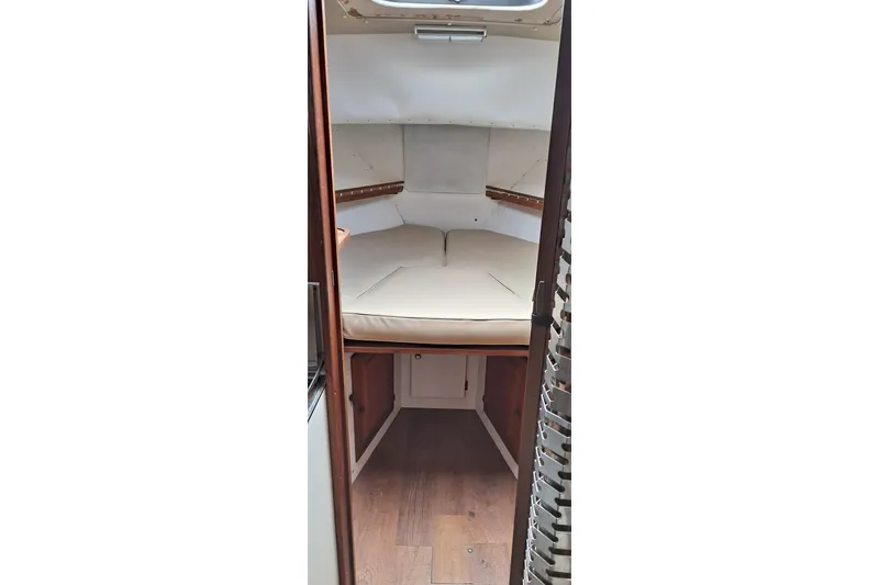 Slide: The Image of 1979 Mainship 34 Sedan cabin interior with bed and wooden flooring. - 8
