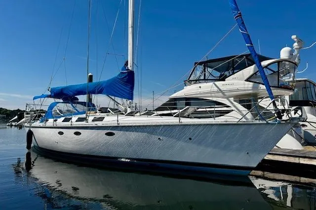 The Image of 1986 Hunter Passage 450 sailboat docked in marina under clear blue sky. - 0