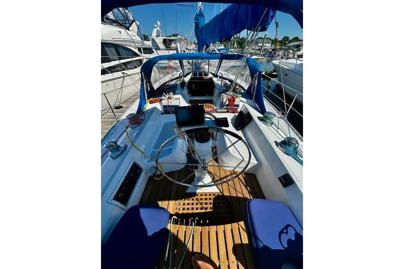 Slide: The Image of Cockpit of 1986 Hunter Passage 450 sailboat with blue canopy and wooden deck. - 13