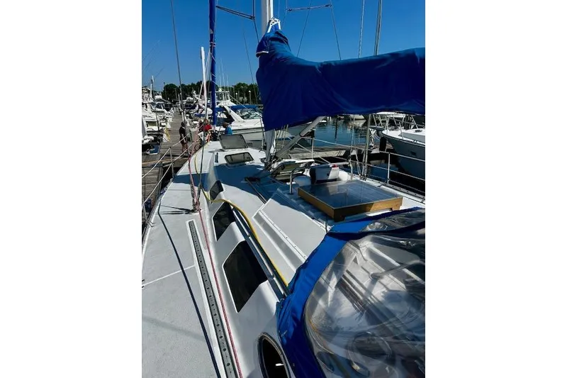 Slide: The Image of 1986 Hunter Passage 450 sailboat docked at marina, featuring blue sail cover. - 15
