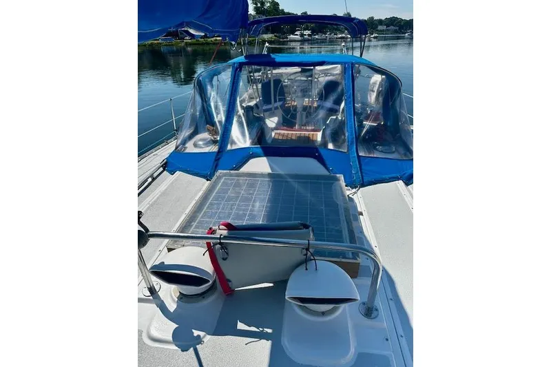 Slide: The Image of 1986 Hunter Passage 450 sailboat with blue canopy and solar panel on deck. - 20