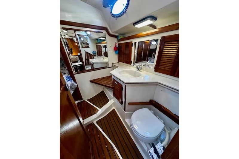 Slide: The Image of Interior of 1986 Hunter Passage 450 yacht bathroom with wooden accents and porthole. - 28