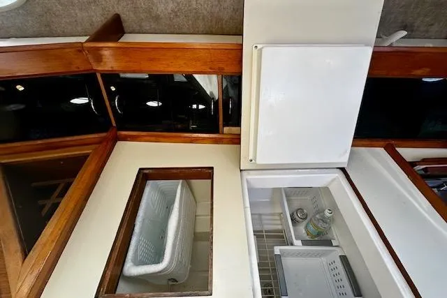 Slide: The Image of Interior view of 1986 Hunter Passage 450 yacht with wooden trim and open refrigerator. - 30