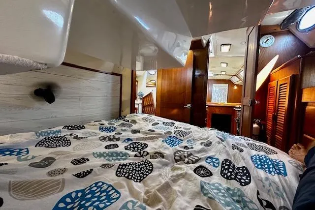 Slide: The Image of Interior of 1986 Hunter Passage 450 sailboat with patterned bedding and wooden cabinetry. - 32
