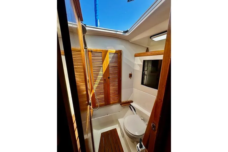 Slide: The Image of Interior of 1986 Hunter Passage 450 yacht bathroom with wooden accents and skylight. - 34
