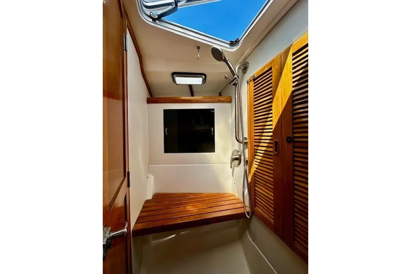 Slide: The Image of Interior of 1986 Hunter Passage 450 yacht shower with wooden accents and skylight. - 36