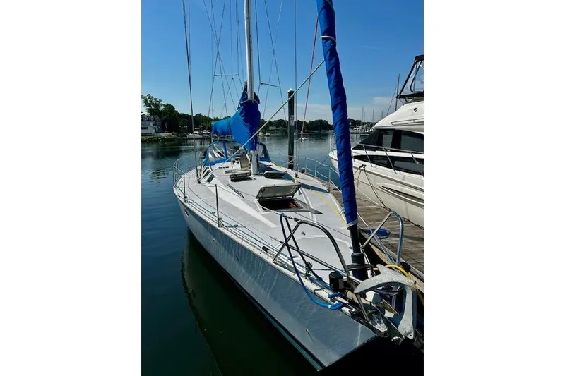 Slide: The Image of 1986 Hunter Passage 450 sailboat docked, featuring blue sail cover and sleek design. - 4