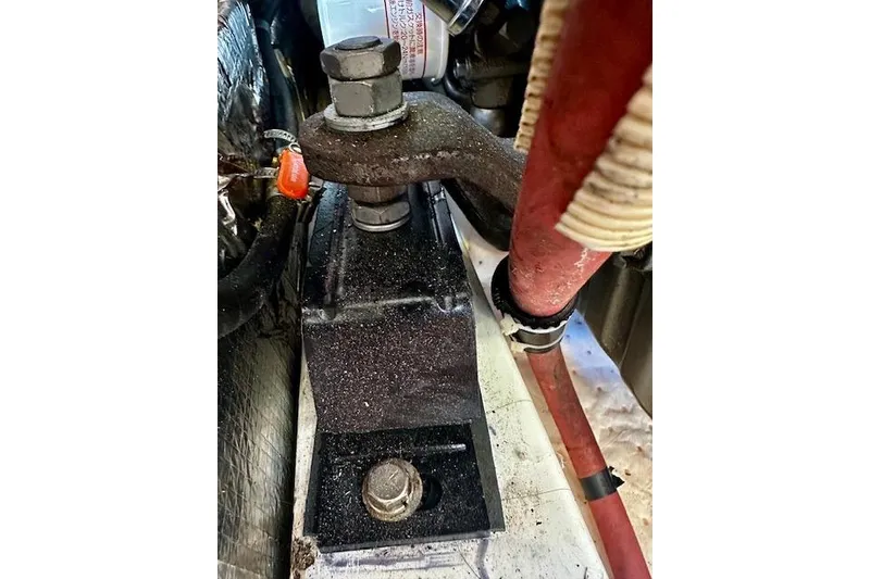 Slide: The Image of Engine component of 1986 Hunter Passage 450 sailboat, featuring bolts and hoses. - 41