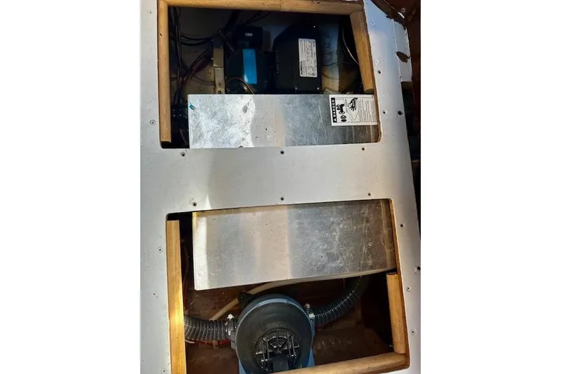 Slide: The Image of Electrical components inside a 1986 Hunter Passage 450 yacht, featuring wiring and metal panels. - 45