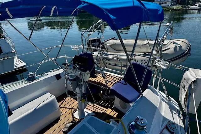 Slide: The Image of 1986 Hunter Passage 450 sailboat cockpit with blue canopy and docked dinghy. - 5