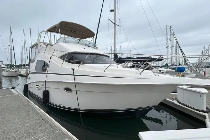 The Image of 2003 Silverton 35 Motor Yacht docked at marina, surrounded by sailboats. - 0