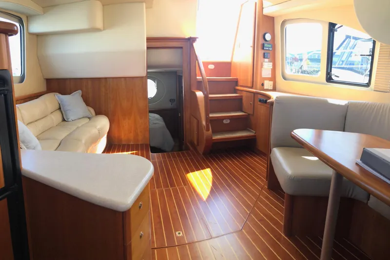 Slide: The Image of Interior of 2003 Silverton 35 Motor Yacht with wood flooring and cozy seating area. - 10
