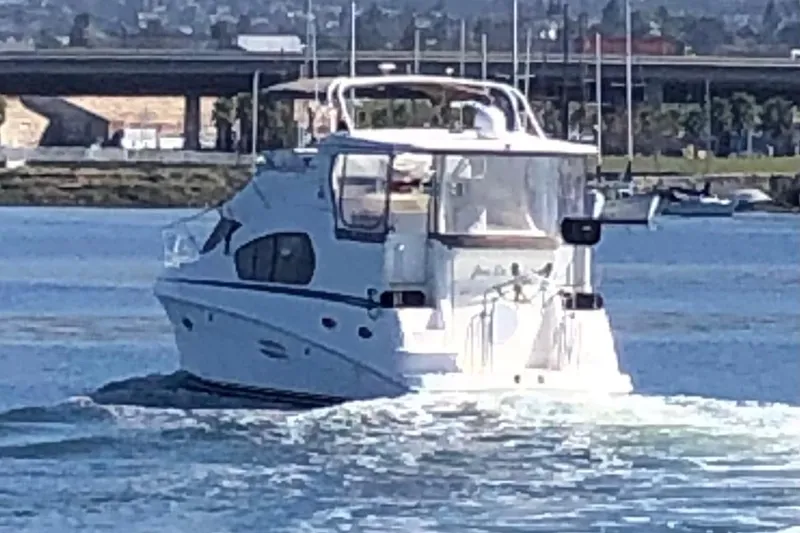 Slide: The Image of 2003 Silverton 35 Motor Yacht cruising on a sunny day near a bridge. - 21