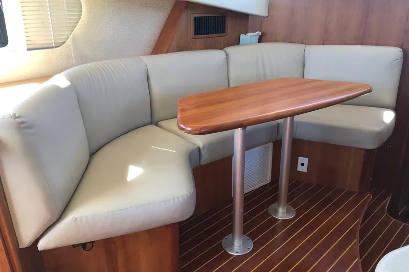 Slide: The Image of 2003 Silverton 35 Motor Yacht interior with beige seating and wooden table. - 4