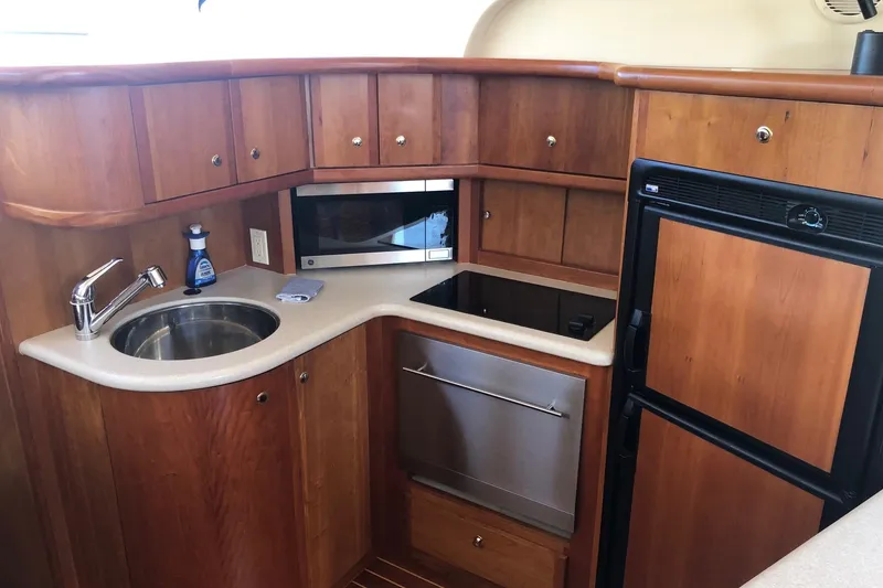 Slide: The Image of 2003 Silverton 35 Motor Yacht kitchen with wood cabinets, sink, microwave, and fridge. - 5