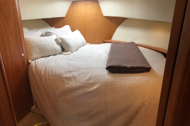 Slide: The Image of Cozy bedroom interior of 2003 Silverton 35 Motor Yacht with plush bedding. - 8