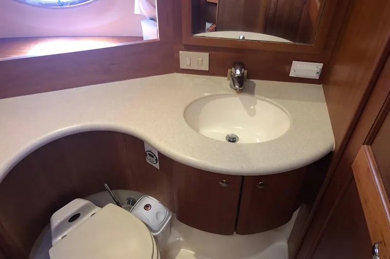 Slide: The Image of 2003 Silverton 35 Motor Yacht bathroom with sink, toilet, and wooden cabinetry. - 9