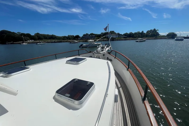 Slide: The Image of 1990 Grand Banks 46 Classic yacht on calm water under clear blue sky. - 10