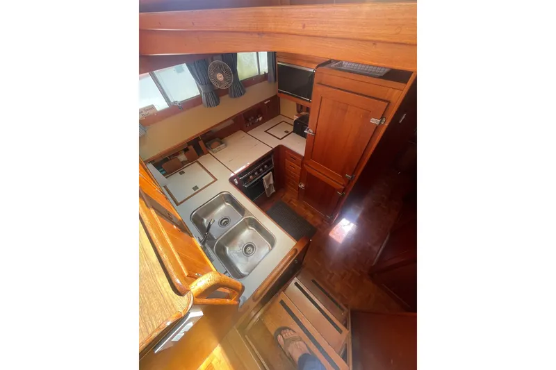 Slide: The Image of Interior of 1990 Grand Banks 46 Classic yacht, featuring a compact kitchen with dual sinks. - 12