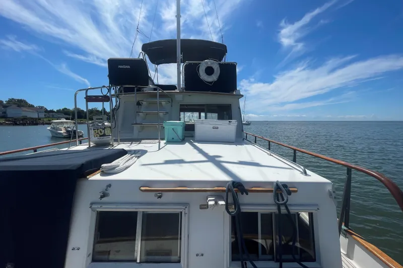 Slide: The Image of 1990 Grand Banks 46 Classic yacht on calm waters under a clear blue sky. - 13